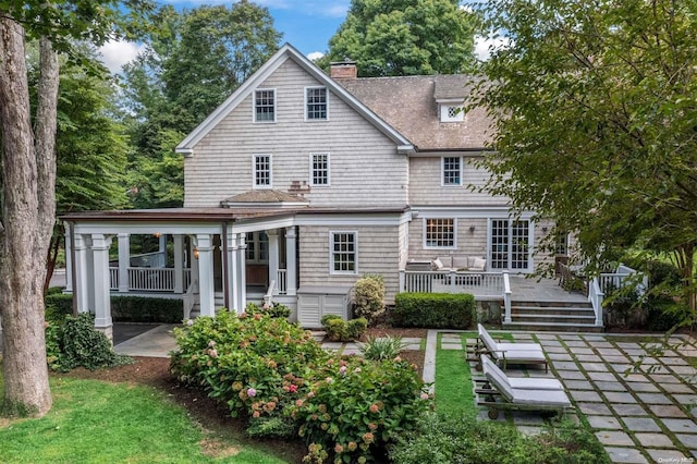 rear view of house with covered porch and a deck