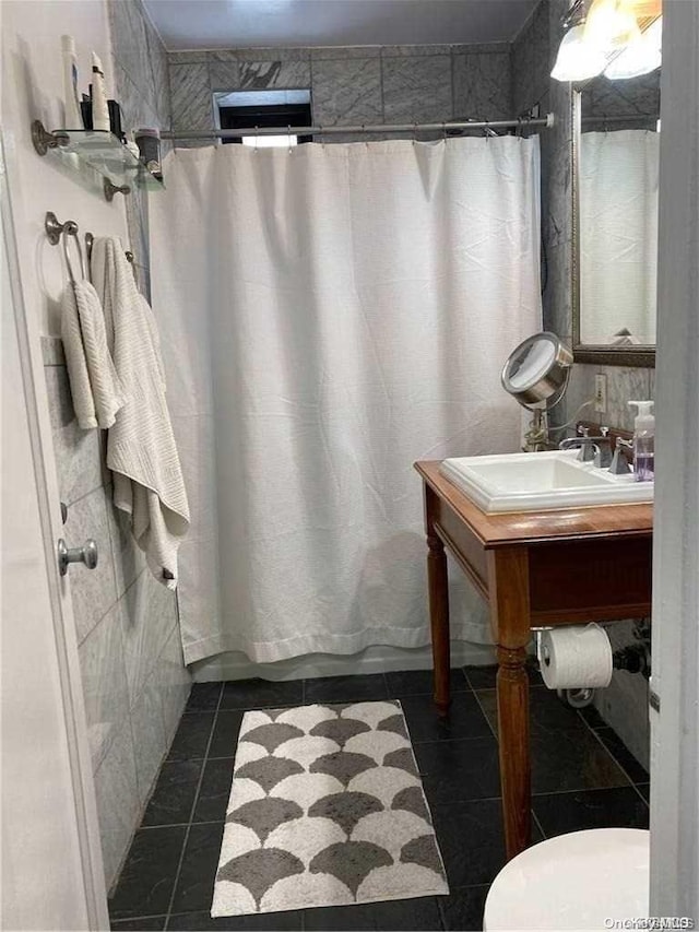 bathroom featuring toilet, vanity, tile patterned floors, and tile walls