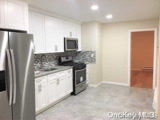 kitchen featuring appliances with stainless steel finishes, tasteful backsplash, sink, stone countertops, and white cabinets