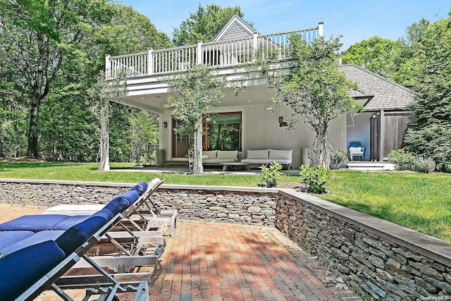 back of house with a yard, a balcony, a patio, and an outdoor hangout area