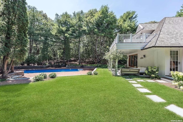 view of yard featuring an outdoor living space and a balcony