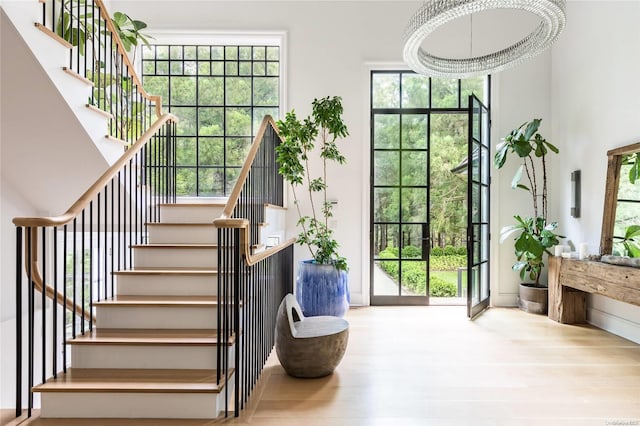 interior space with hardwood / wood-style floors, plenty of natural light, and a notable chandelier