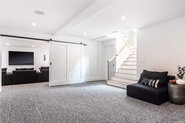 living room with beamed ceiling, a barn door, and carpet floors