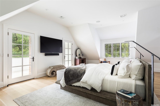 bedroom with multiple windows, vaulted ceiling, and light wood-type flooring