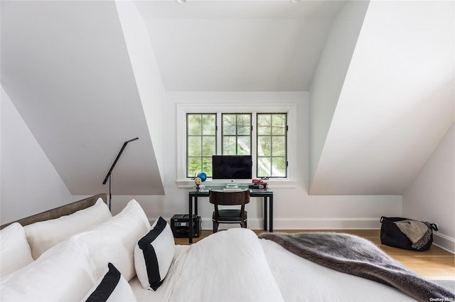 bedroom with wood-type flooring and vaulted ceiling