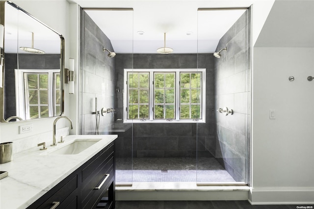 bathroom featuring vanity, a healthy amount of sunlight, and a shower with door