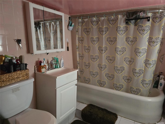 full bathroom with tile patterned flooring, shower / bath combination with curtain, toilet, vanity, and tile walls