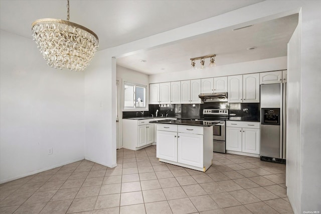 kitchen with decorative backsplash, appliances with stainless steel finishes, an inviting chandelier, white cabinets, and hanging light fixtures