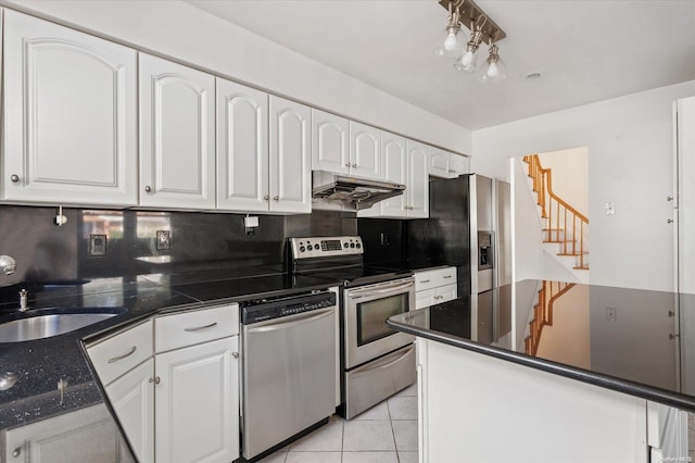 kitchen featuring decorative backsplash, appliances with stainless steel finishes, sink, white cabinetry, and light tile patterned flooring