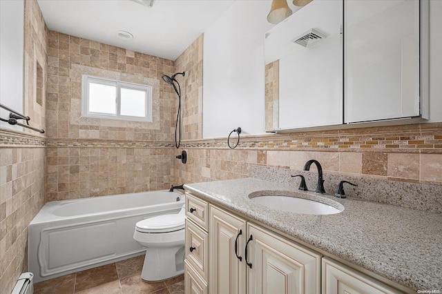 full bathroom with vanity, tiled shower / bath, toilet, tile walls, and a baseboard radiator