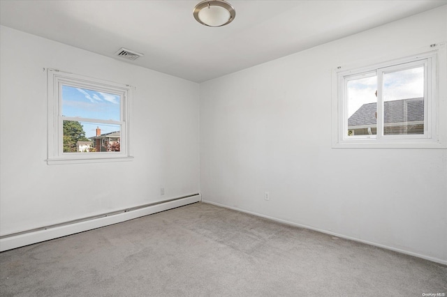 carpeted empty room featuring a baseboard heating unit