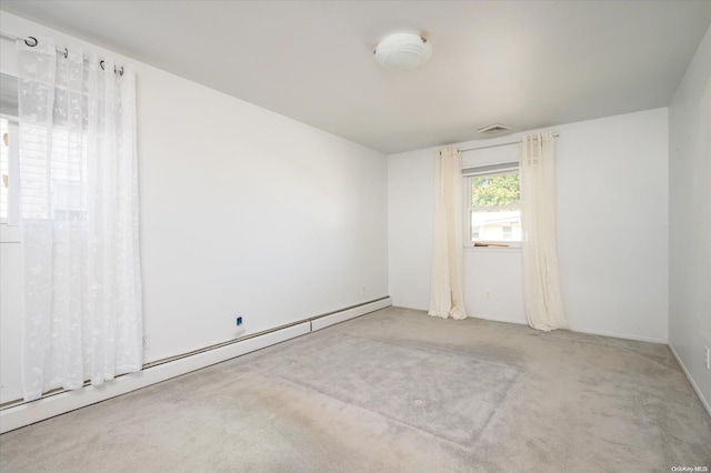 empty room with light colored carpet and a baseboard radiator