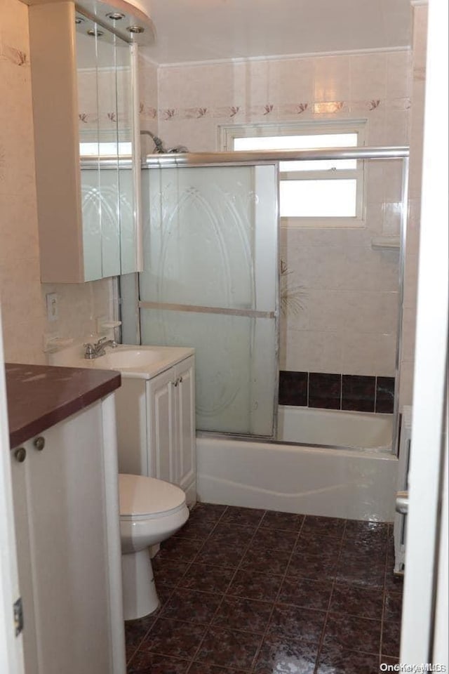 full bathroom with vanity, toilet, and bath / shower combo with glass door