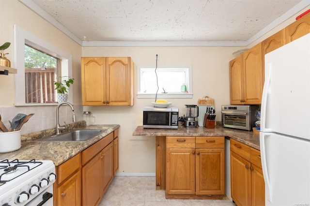 kitchen featuring light tile patterned floors, white appliances, dark stone countertops, and sink