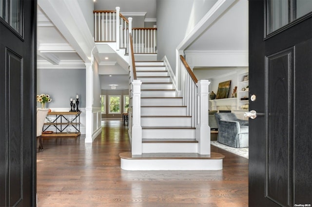 entryway featuring dark hardwood / wood-style flooring, decorative columns, coffered ceiling, crown molding, and beam ceiling