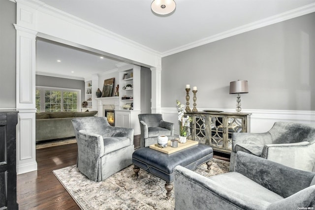 living room featuring dark hardwood / wood-style flooring, ornate columns, and crown molding