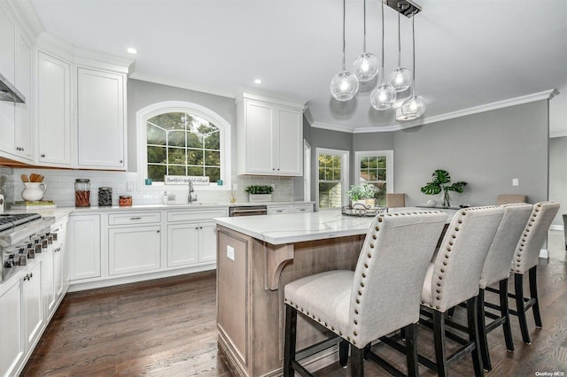 kitchen with white cabinets, dark hardwood / wood-style floors, a center island, and pendant lighting