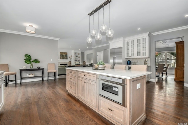 kitchen with dark hardwood / wood-style flooring, a center island, decorative light fixtures, and appliances with stainless steel finishes