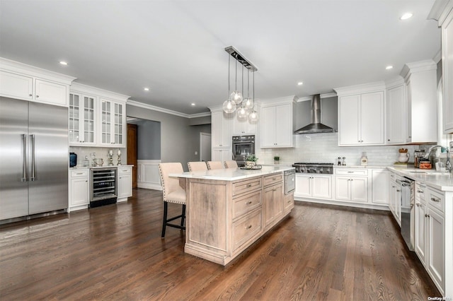 kitchen with white cabinetry, wall chimney exhaust hood, dark wood-type flooring, wine cooler, and appliances with stainless steel finishes