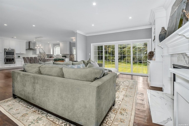 living room with a high end fireplace, wood-type flooring, and crown molding