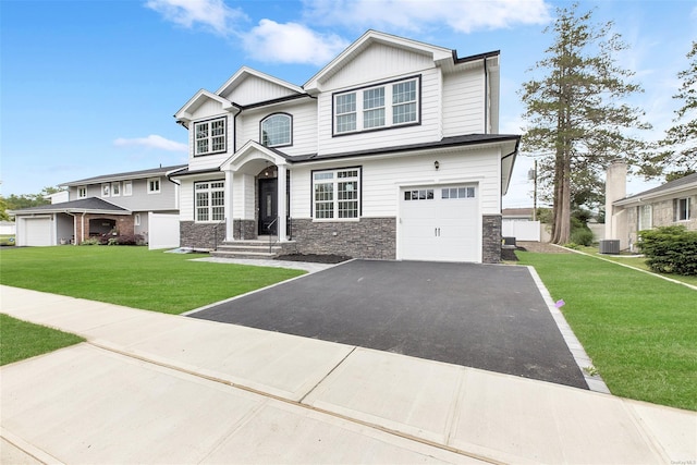 view of front of house featuring a front yard, cooling unit, and a garage