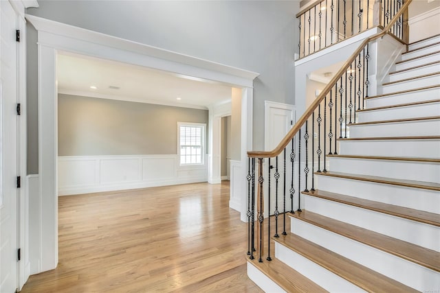 stairway featuring ornamental molding and hardwood / wood-style floors