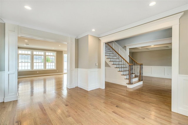 spare room featuring ornamental molding and light hardwood / wood-style floors