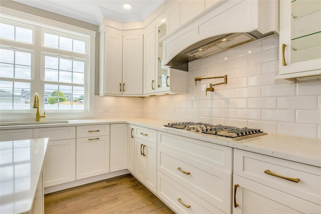 kitchen with white cabinetry, sink, backsplash, and stainless steel gas stovetop