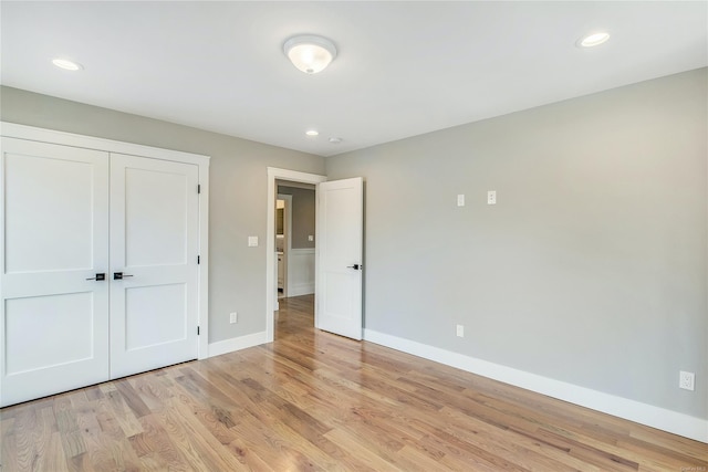 unfurnished bedroom featuring light wood-type flooring and a closet