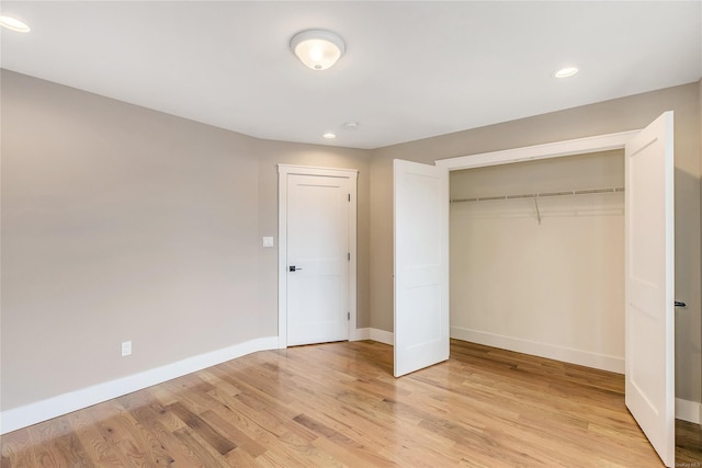 unfurnished bedroom with a closet and light hardwood / wood-style floors