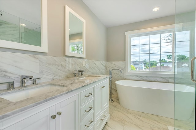 bathroom featuring vanity, tile walls, and a bath