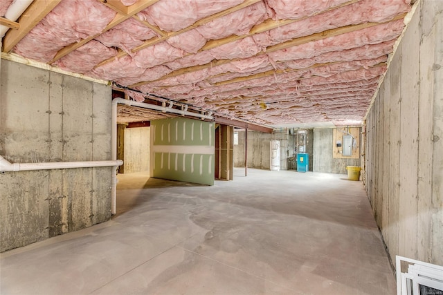 basement featuring electric panel and water heater