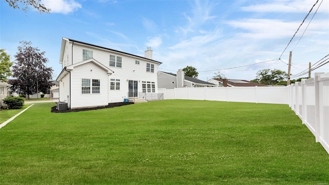 back of house featuring central AC and a lawn