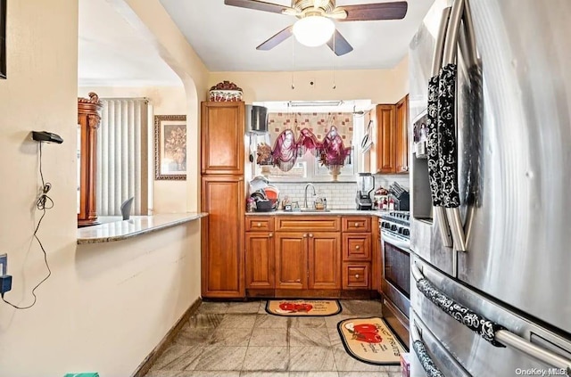 kitchen featuring backsplash, ceiling fan, sink, and stainless steel appliances