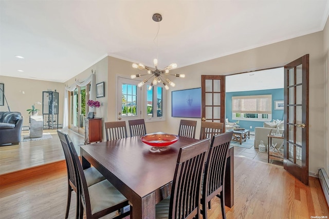 dining space with french doors, a baseboard radiator, a notable chandelier, crown molding, and light wood-type flooring