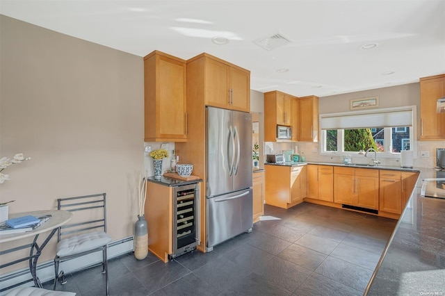 kitchen featuring tasteful backsplash, stainless steel appliances, baseboard heating, light brown cabinets, and wine cooler