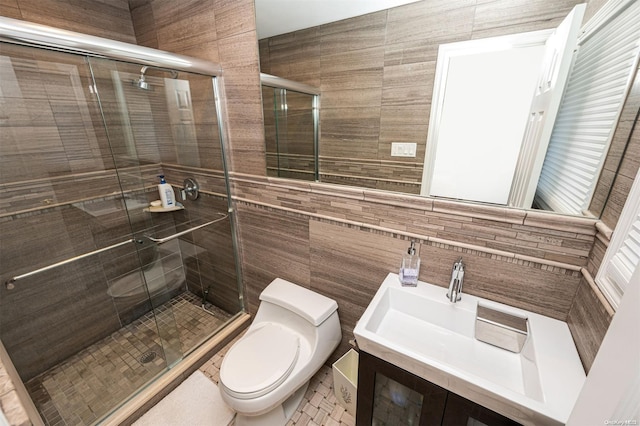 bathroom featuring walk in shower, vanity, toilet, and tile walls