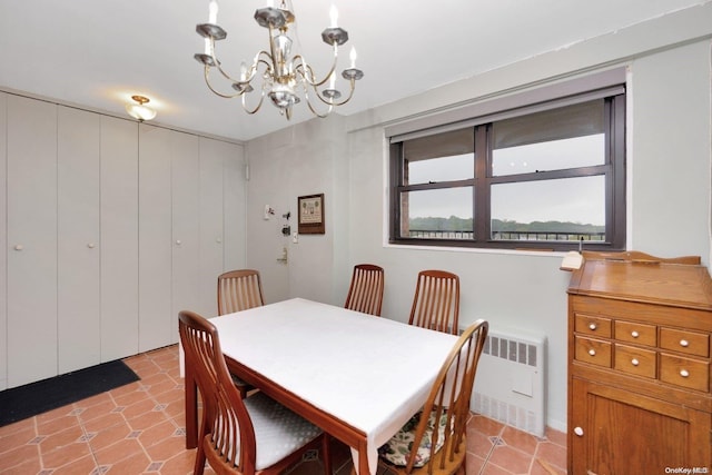 dining space featuring a notable chandelier and radiator