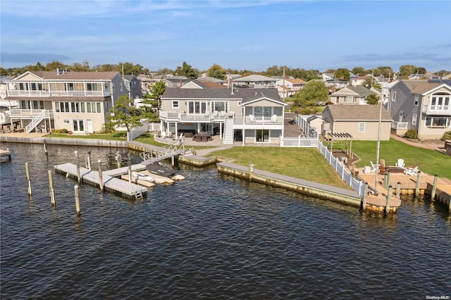 exterior space featuring a lawn, a balcony, a water view, and a patio