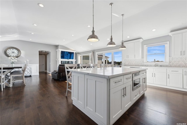 kitchen featuring white cabinetry, vaulted ceiling, and a healthy amount of sunlight