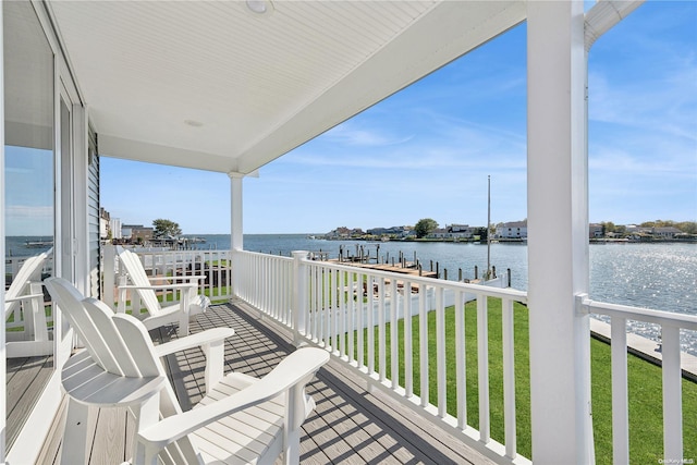 balcony with a water view and a dock