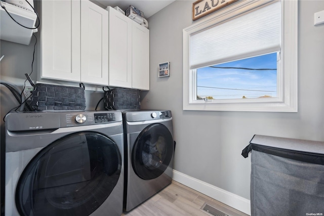 laundry room featuring light hardwood / wood-style floors, cabinets, and independent washer and dryer