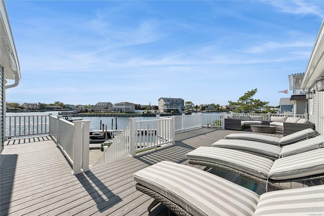 wooden deck with an outdoor living space and a water view