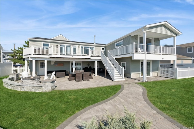 rear view of property featuring a patio area, a yard, a wooden deck, and an outdoor hangout area