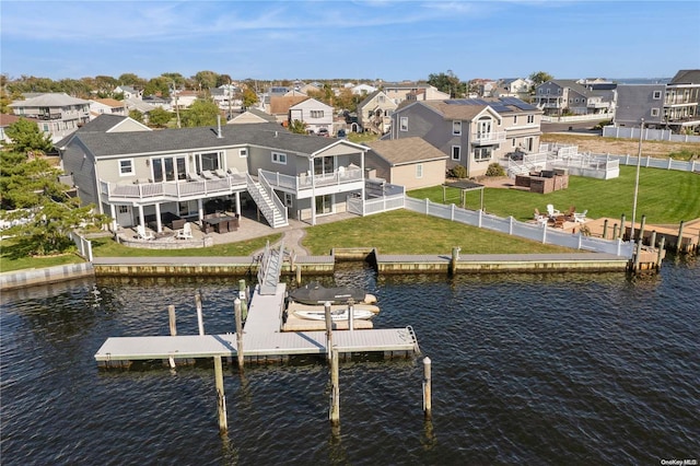 dock area with a lawn, a patio area, and a deck with water view