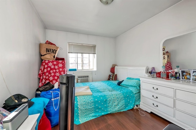 bedroom featuring a wall mounted air conditioner and dark wood-type flooring