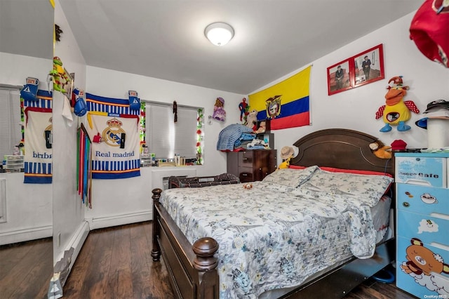 bedroom featuring a baseboard heating unit and dark wood-type flooring