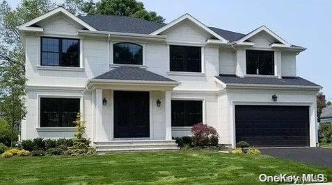 view of front facade with a garage and a front lawn