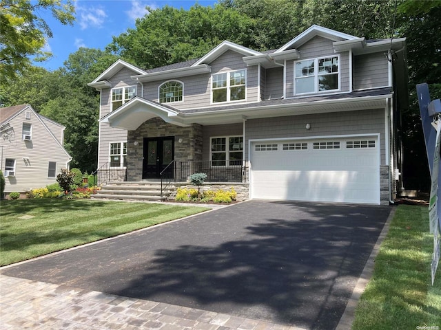 view of front of home with french doors, a garage, and a front lawn