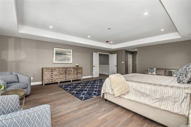 bedroom featuring hardwood / wood-style flooring and a raised ceiling